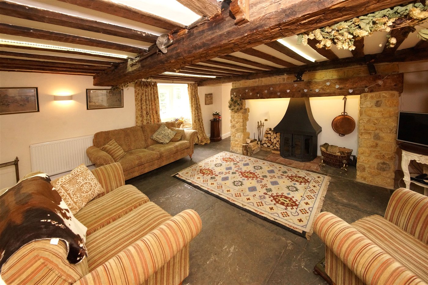 Int&eacute;rieur r&eacute;nov&eacute; avec poutres apparentes, po&ecirc;le &agrave; bois et chemin&eacute;e en pierre